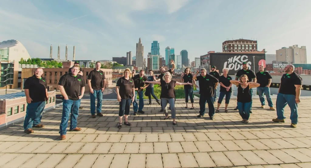 morgan miller plumbing team on a rooftop with the kc skyline in the background