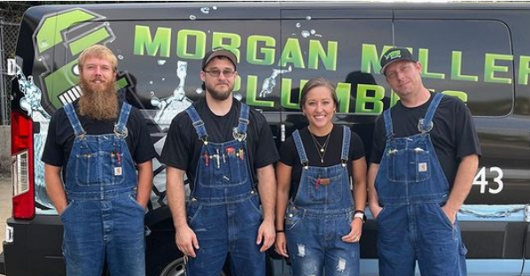 Employees wearing coveralls pose