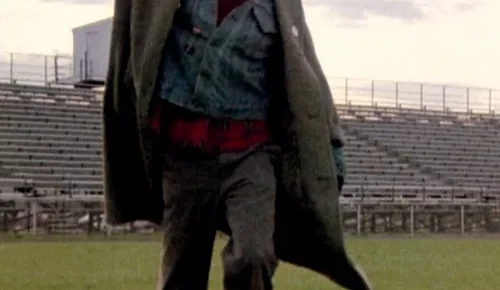Man raising fist while walking through football field