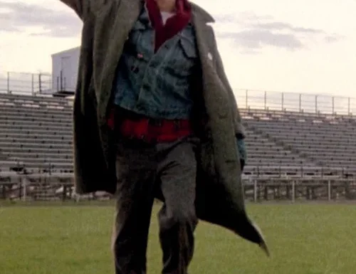 Man raising fist while walking through football field